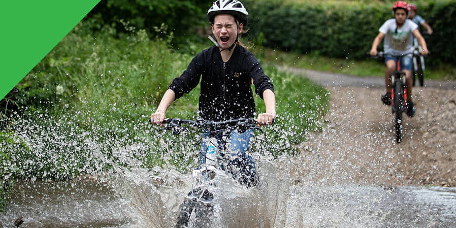 MTB Groene Route - Kind rijdt door water met mountainbike